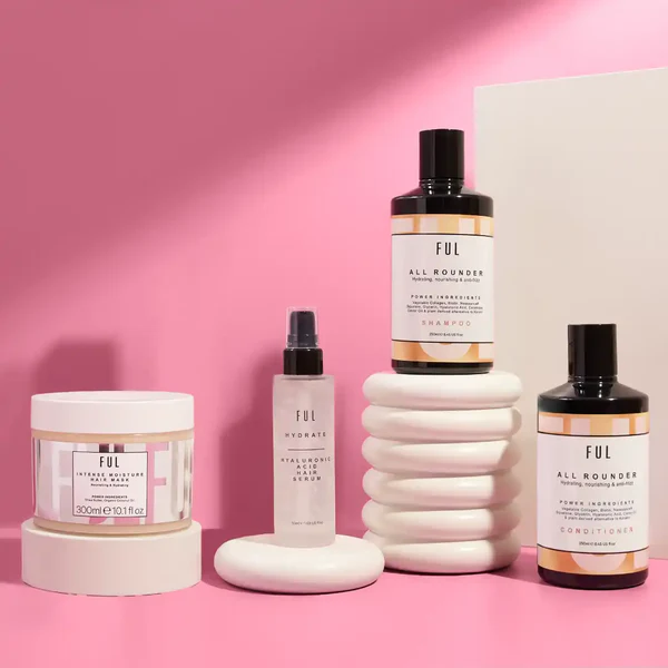 collection skincare products white ceramic stands pink backdrop