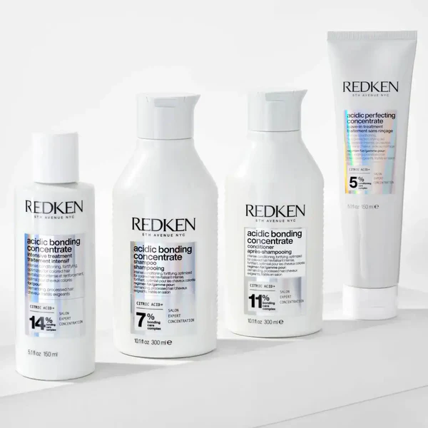 four white redken hair treatment bottles blue text concentration percentages 459